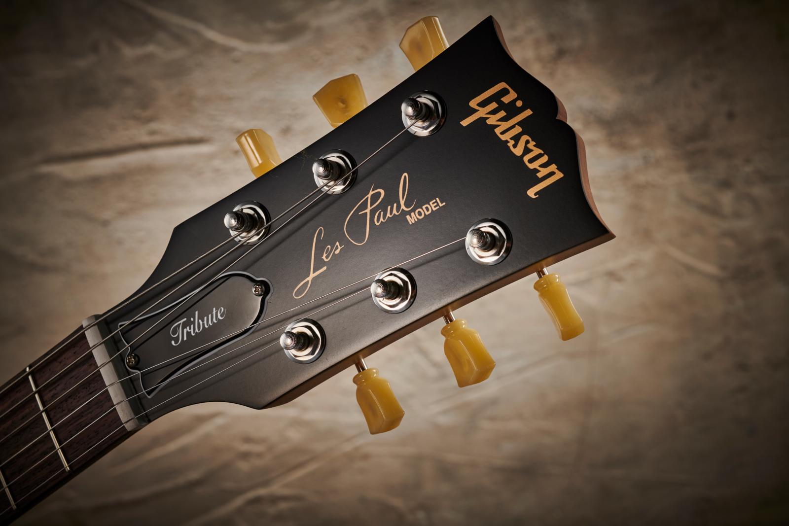 Detail of the Vintage Deluxe tuners and headstock on a Gibson 2019 Modern Collection Les Paul Tribute electric guitar with a Satin Honeyburst finish