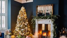 Christmas living room with a Christmas tree and a mantelpiece with a large garland 