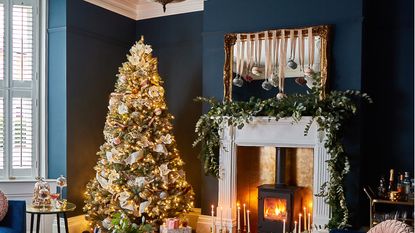 Christmas living room with a Christmas tree and a mantelpiece with a large garland 