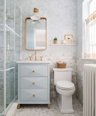 small bathroom with brass mirror, handles and lighting