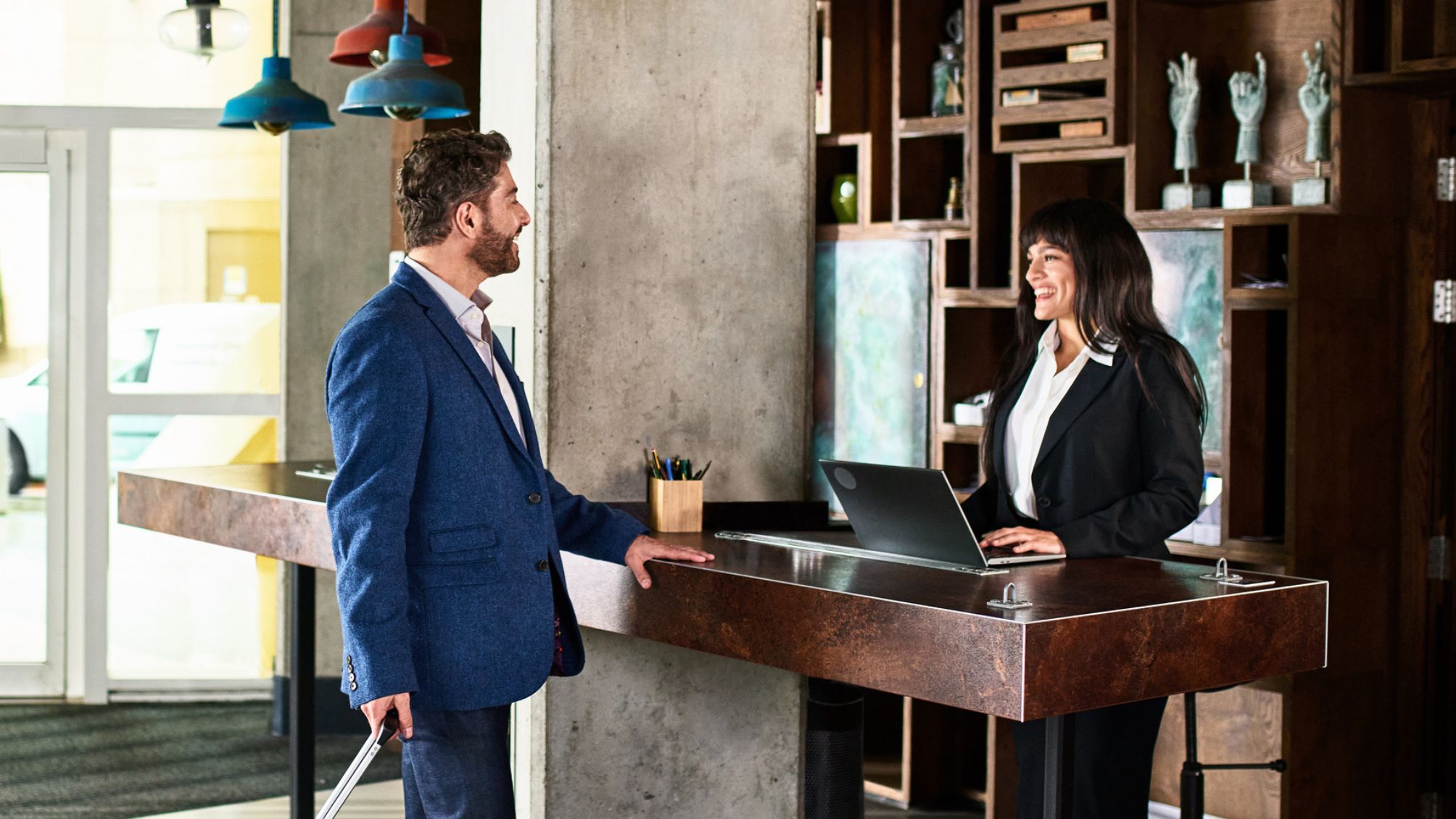 Businessman with suitcase arriving at hotel reception