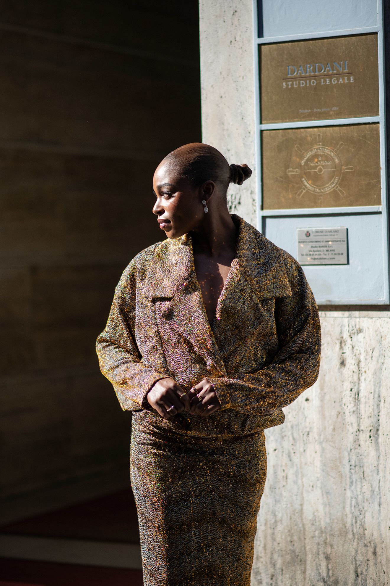 a black woman with a bun in a tweed outfit