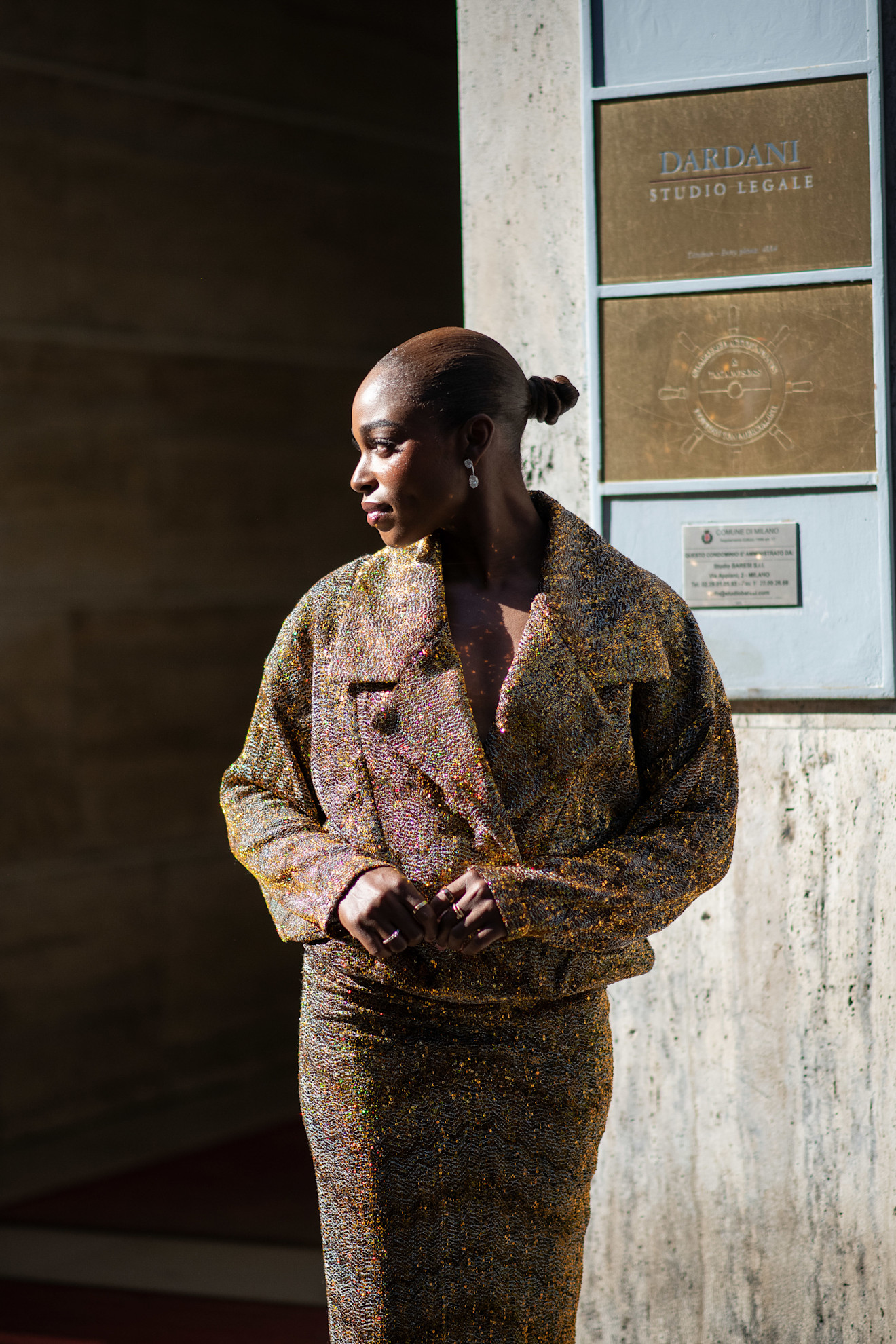 a black woman with a bun in a tweed outfit