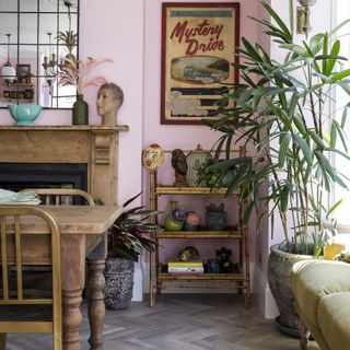 Pink dining room with a dark wood table, fireplace and cabinet