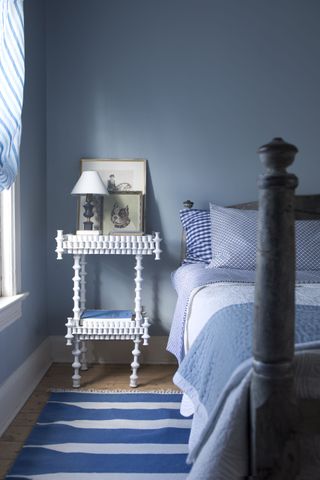 A bedroom with blue and white striped rug