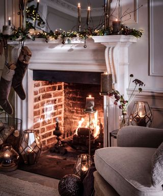 Cozy christmas fireplace decorated with string lights, foliage and ornaments