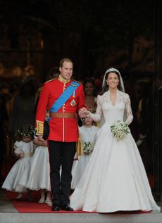 prince william and kate middleton leaving the church after their wedding ceremony - prince william wears a military suit and kate middleton wears a white lace wedding dress