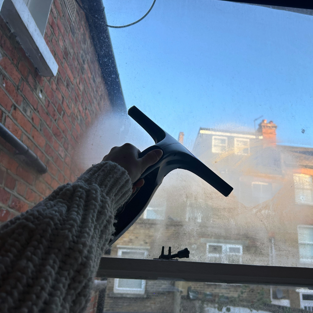 Megan holding the Daewoo cleaning vac on her window, one of the best window vacs