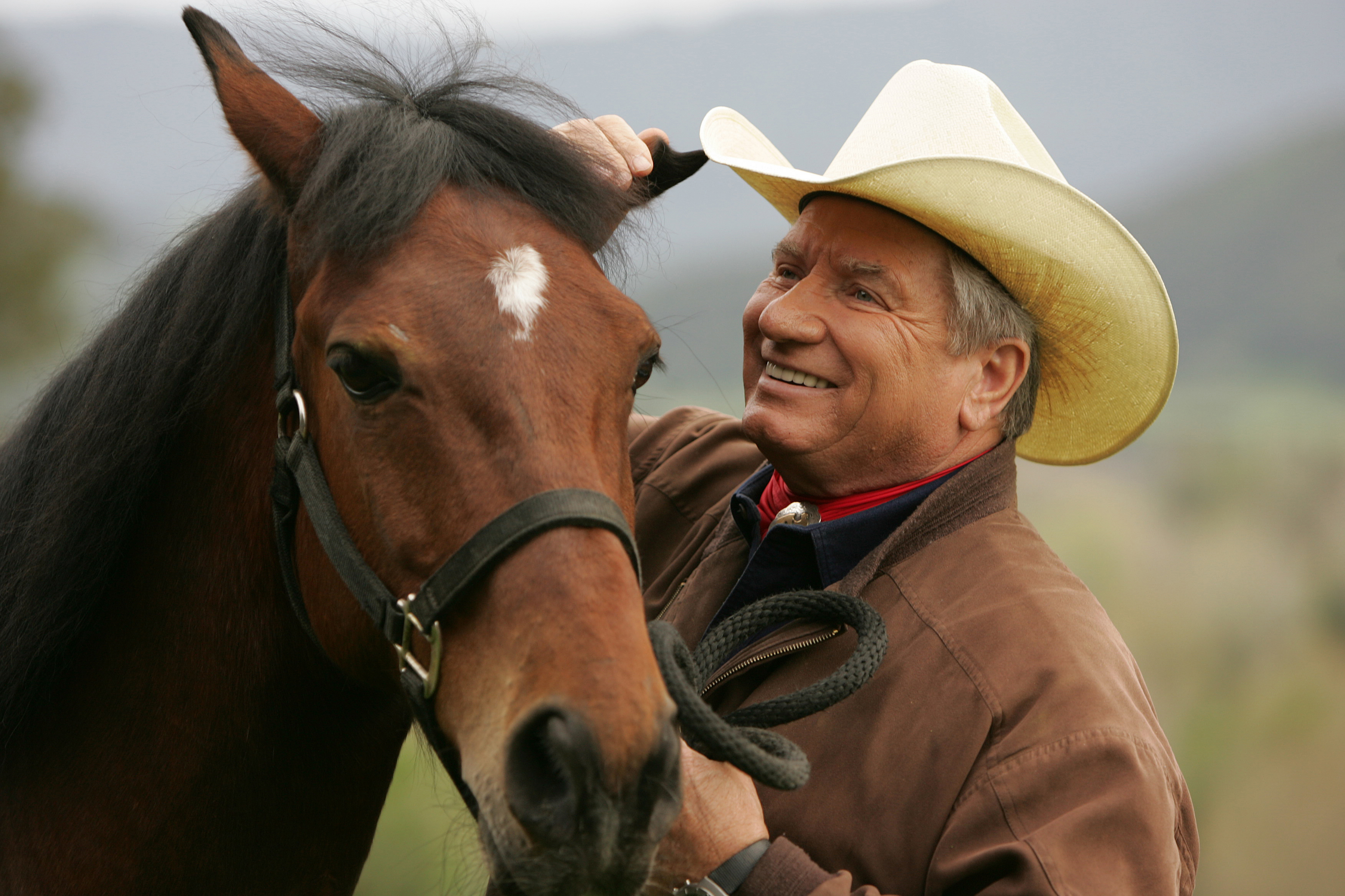 Monty Roberts petting a horse