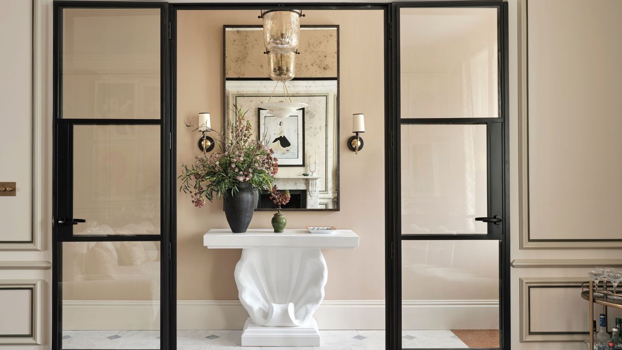 A foyer with a vintage pendant light, and two vintage wall lights 
