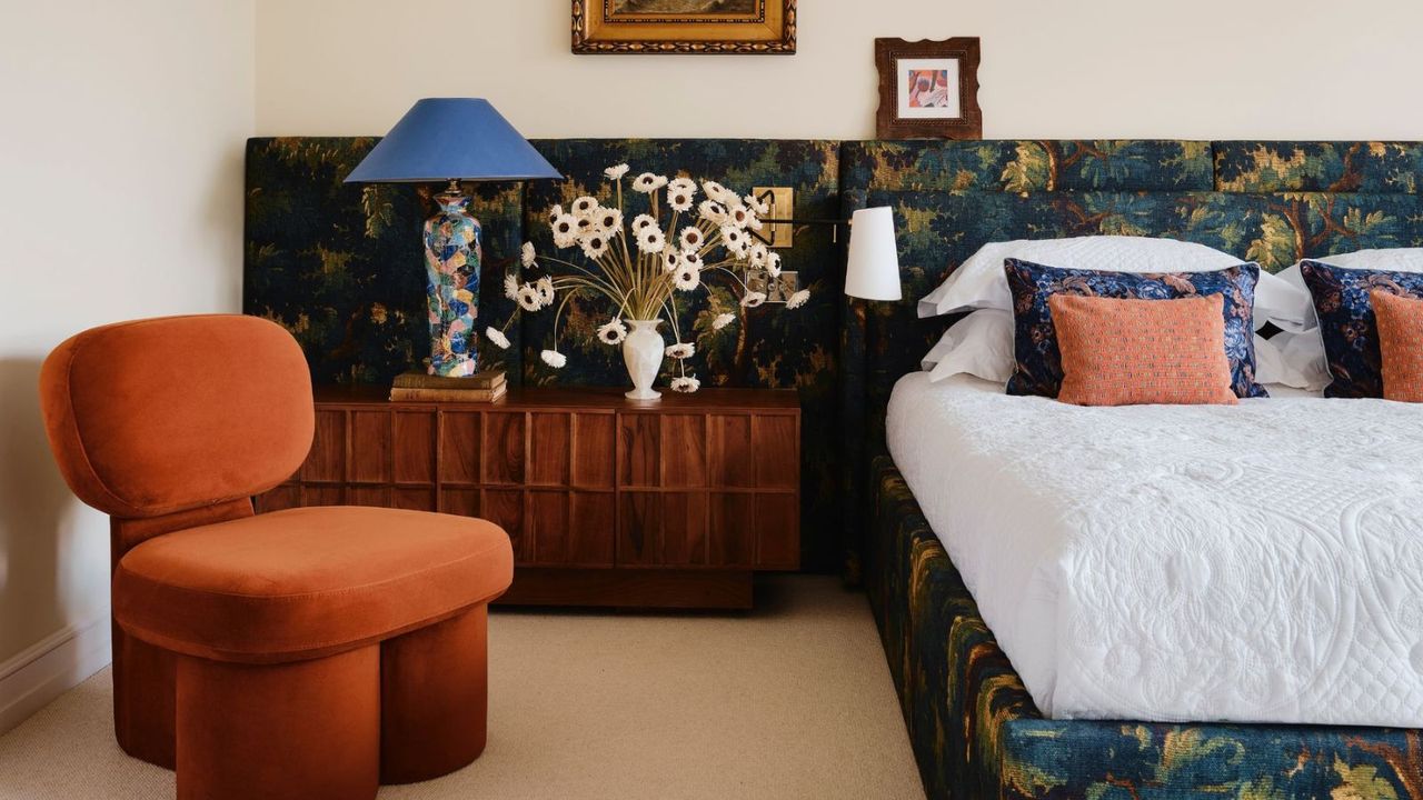 eclectic modern bedroom with a wall to wall headboard covered in tapestry fabric 