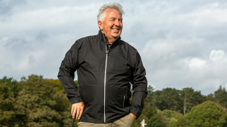 A golfer wears the Stuburt Leaden Lightweight Waterproof Jacket