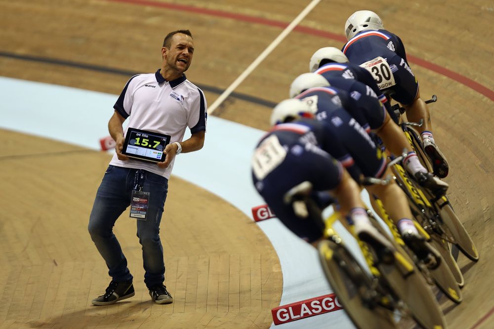 A coach from France encourages his team in the first round of the men's pursuit