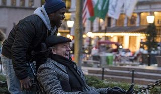 The Upside Kevin Hart and Bryan Cranston joy riding on a wheelchair in the city