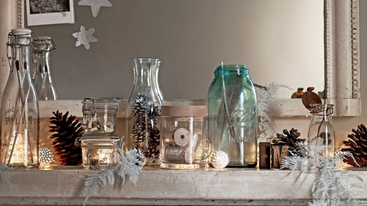 Christmas mantel decorated with pine cones in glass jars