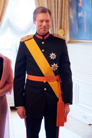 Grand Duke Henri wearing a yellow sash and military uniform