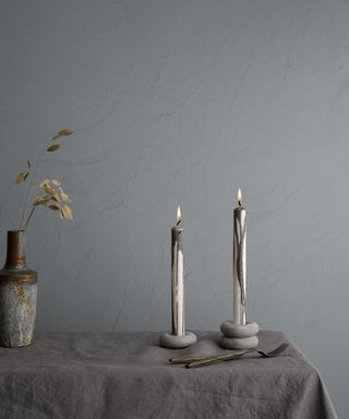 Table setting with silver gray walll and candles