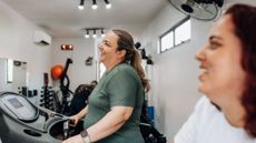 Two smiling women on treadmills