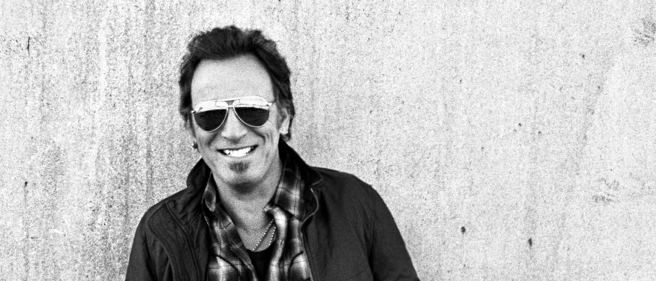 Bruce Springsteen standing against a wall