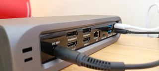 A grey Satechi Thunderbolt 4 dock sitting on a wooden desk