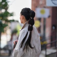 Woman wears beige trench and high bubble ponytail - best k-beauty hair products