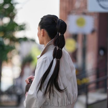 Woman wears beige trench and high bubble ponytail - best k-beauty hair products