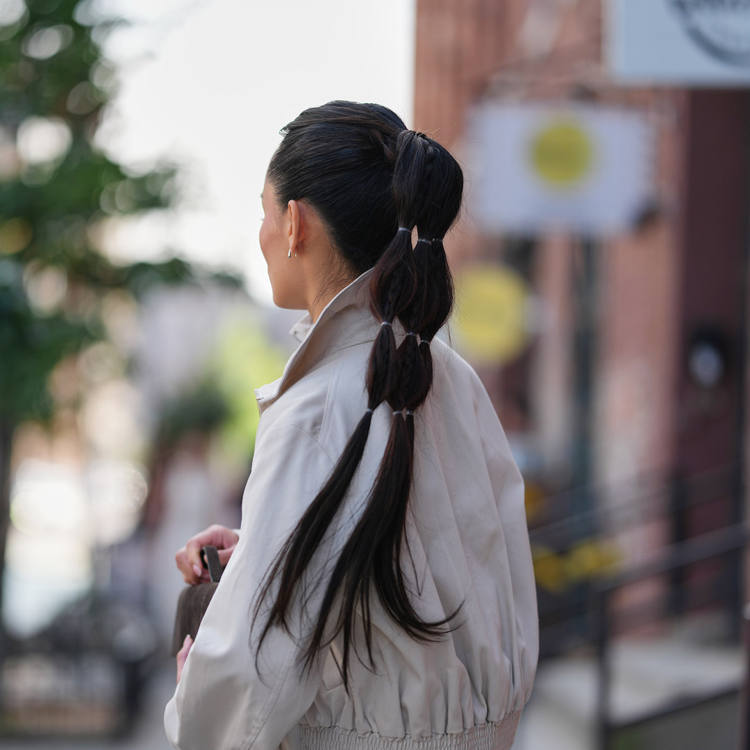 Woman wears beige trench and high bubble ponytail - best k-beauty hair products