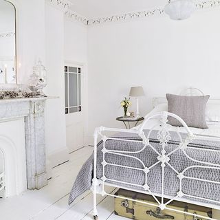 main bedroom with white wall and metal bed