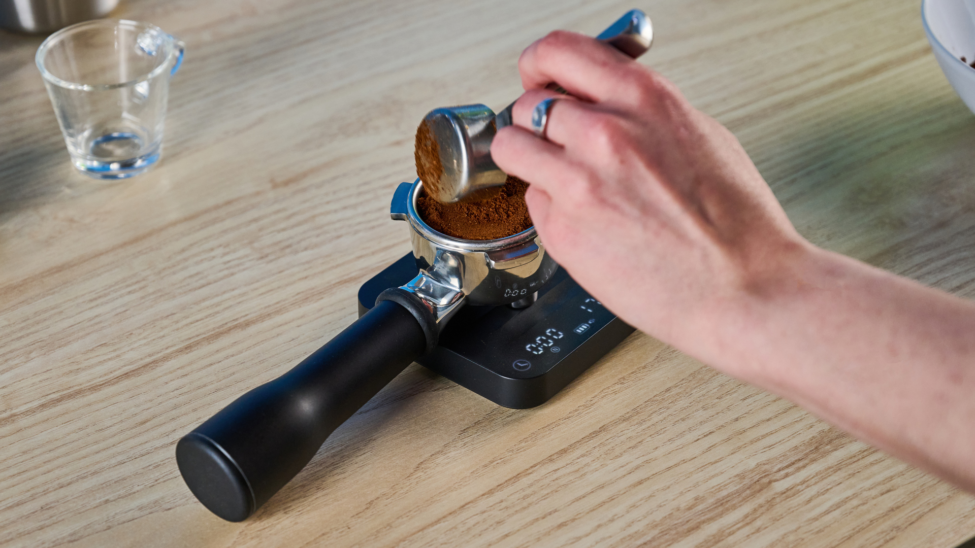 the breville bambino plus / sage bambino plus in stainless steel silver photographed against a blue background shown with its accessories including milk jug, tamper, portafilter, and shown in use extracting espresso