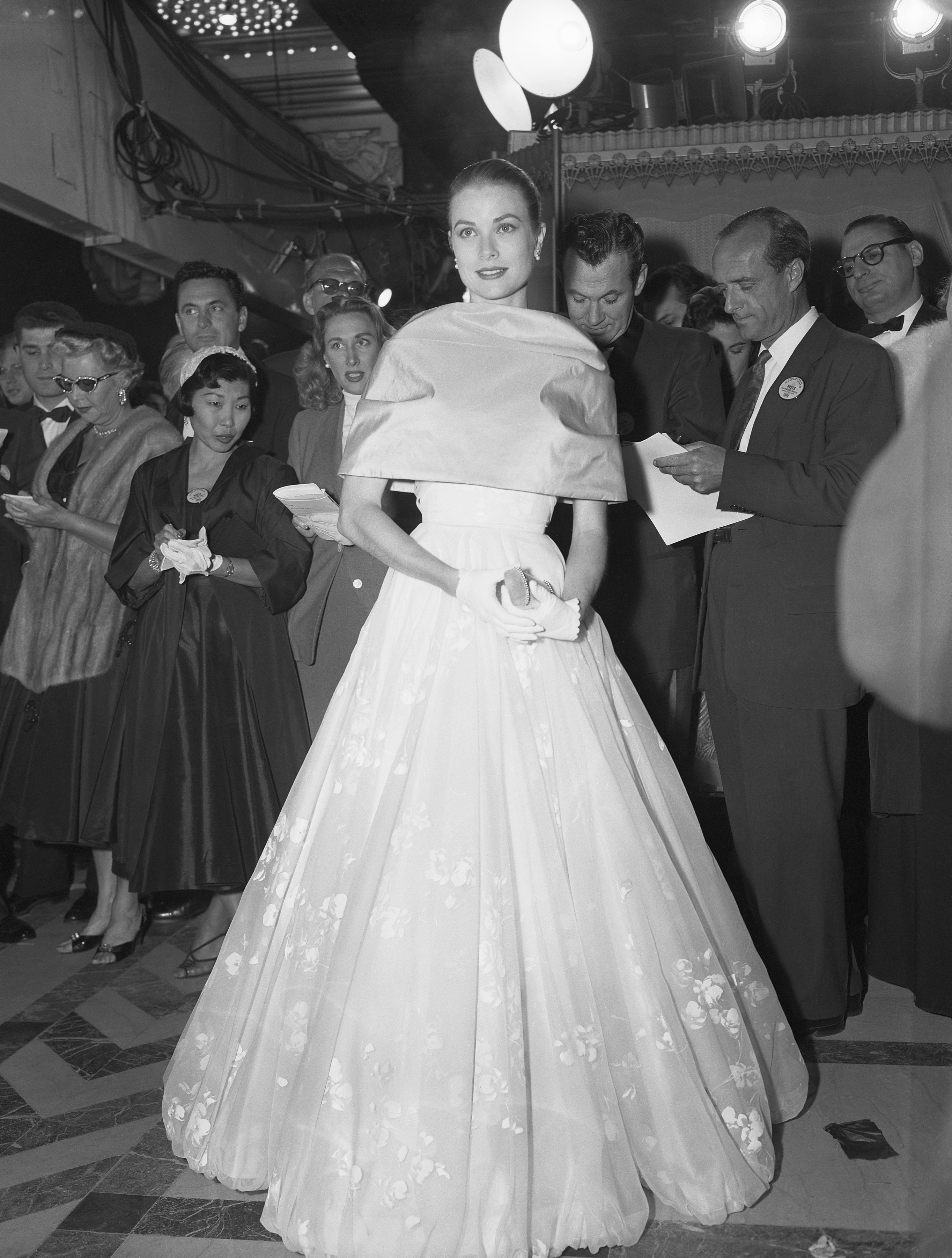 (Original Caption) 3/21/56-Hollywood, California: Resplendent in a beautiful dress and escorted by a studio executive, Grace Kelly makes her last public appearance in Hollywood as she attends the 28th annual Academy Award presentations. Miss Kelly leaves early 3/22 for Monaco and her wedding in April to Prince Rainier.