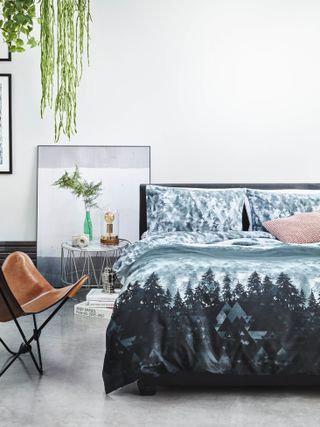 Bedlinen in a white bedroom by George Home, modern gray floor tiles, artwork, metal side table, leather chair, plants