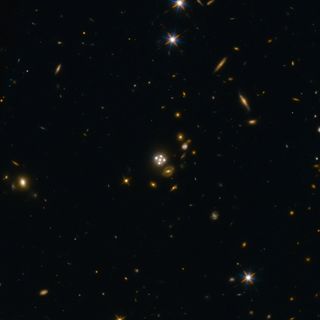 The quasar HE0435-1223, which is one of the five best lensed qusars ever found, is seen in the center of this wide-field view from the Hubble Space Telescope. The central galaxy is actually in the foreground, and a gravitational lens effect creates the fo