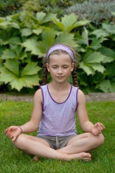 Child Doing Yoga In A Garden