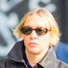 Chloe Sevigny wearing a leather jacket and navy sweatpants