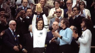 Franz Beckenbauer, captain of West Germany, lifts the FIFA World Cup trophy in 1974.