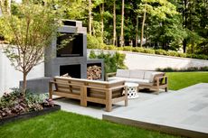 an outdoor living space with a wood outdoor sofa