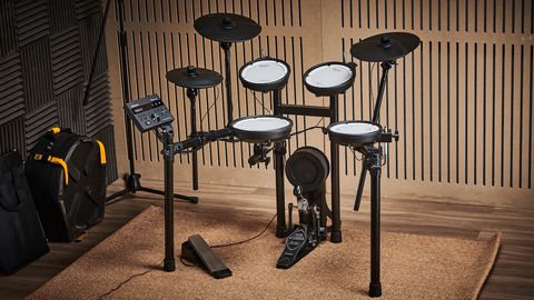 Roland TD-07KV electronic drum set on a rug against a wooden wall