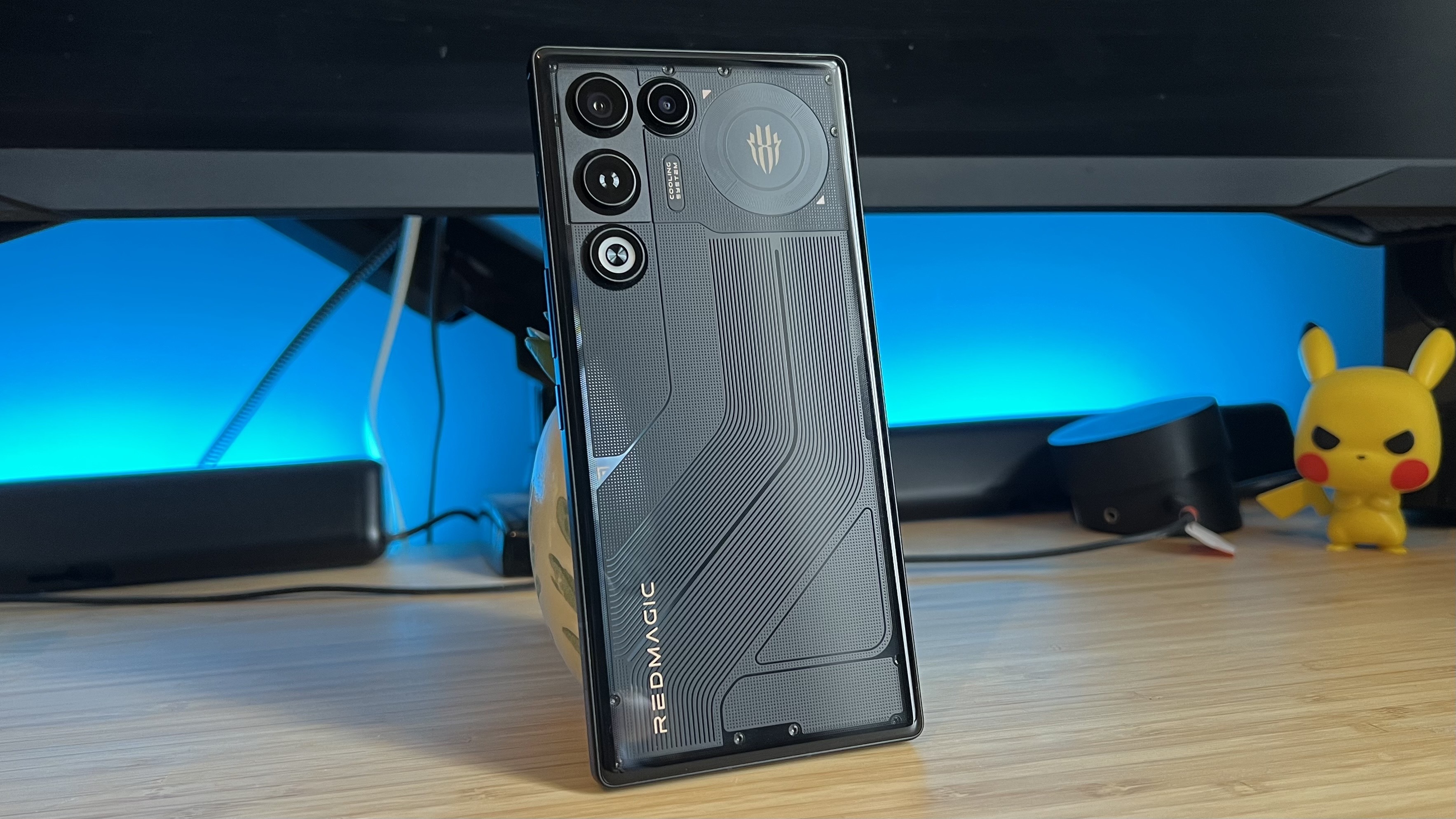 RedMagic 11 Air gaming phone standing on a wooden desk with blue backlighting