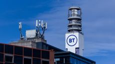 A cell tower bearing the BT logo, sat on top of a building. Decorative: The BT logo is in the brand's trademark purple, against the white of the cell tower. All are set against a blue sky.