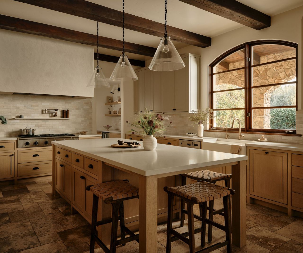 A warm kitchen with wood cabinets and gray countertops