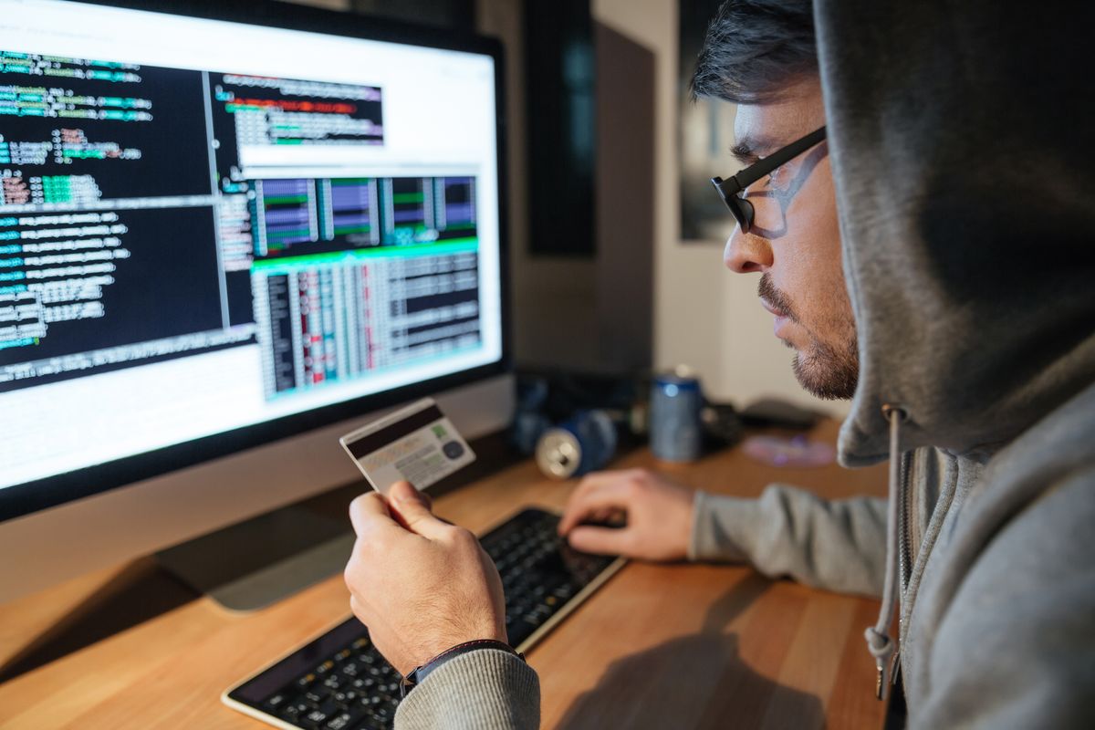 Man entering fake ID information onto a computer