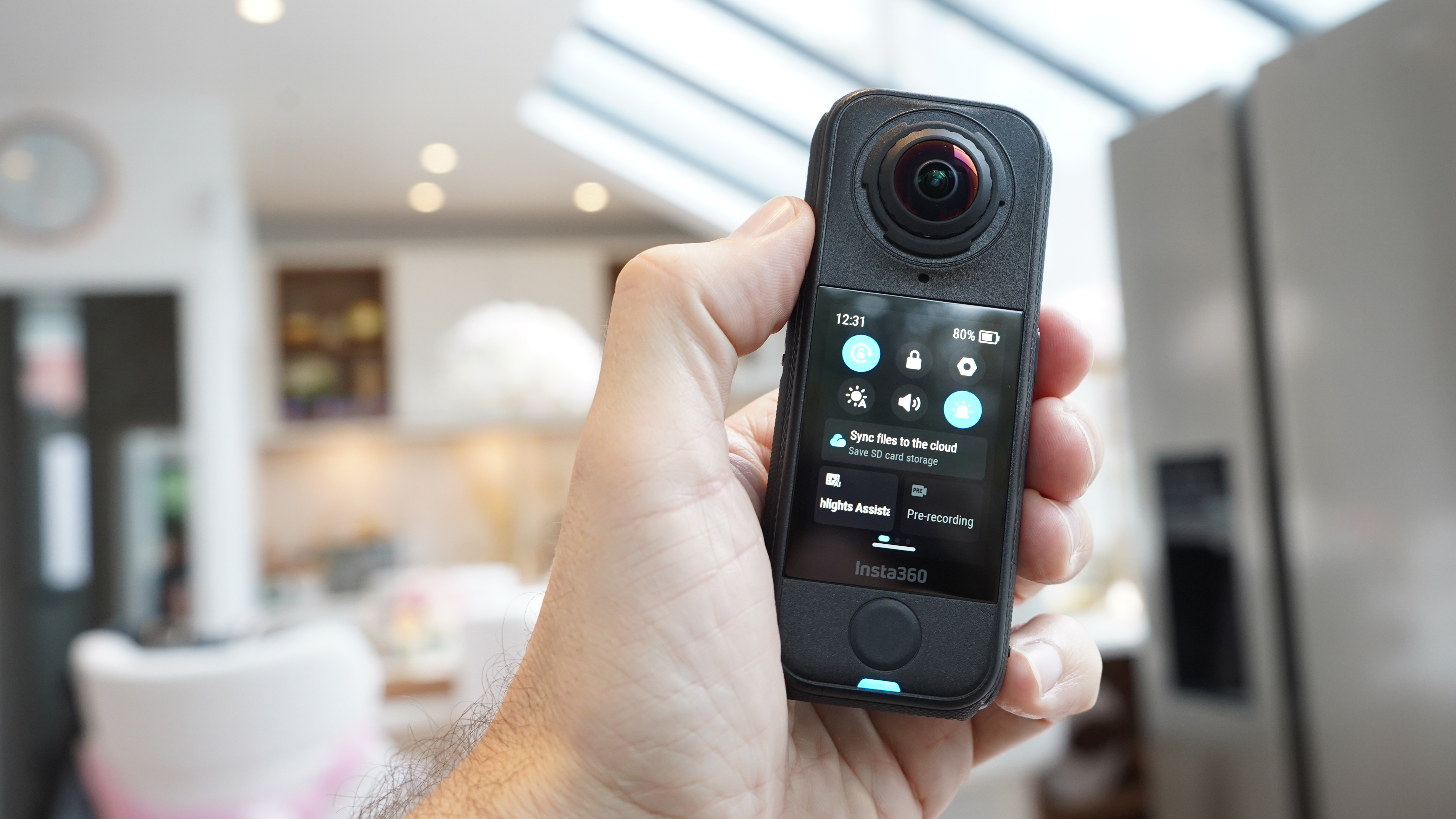 Insta360 X4 Air in hand screen side visible in a kitchen
