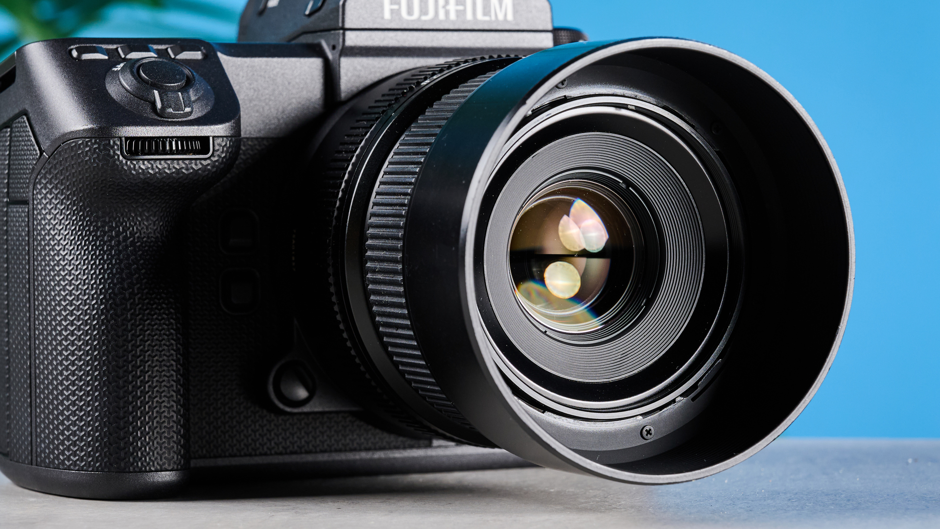 The Fujifilm GFX100 II, a close up shot of the lens and front grip