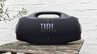 The JBL Boombox 4 on a table outside.