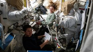 Two astronauts sit in the ISS in space