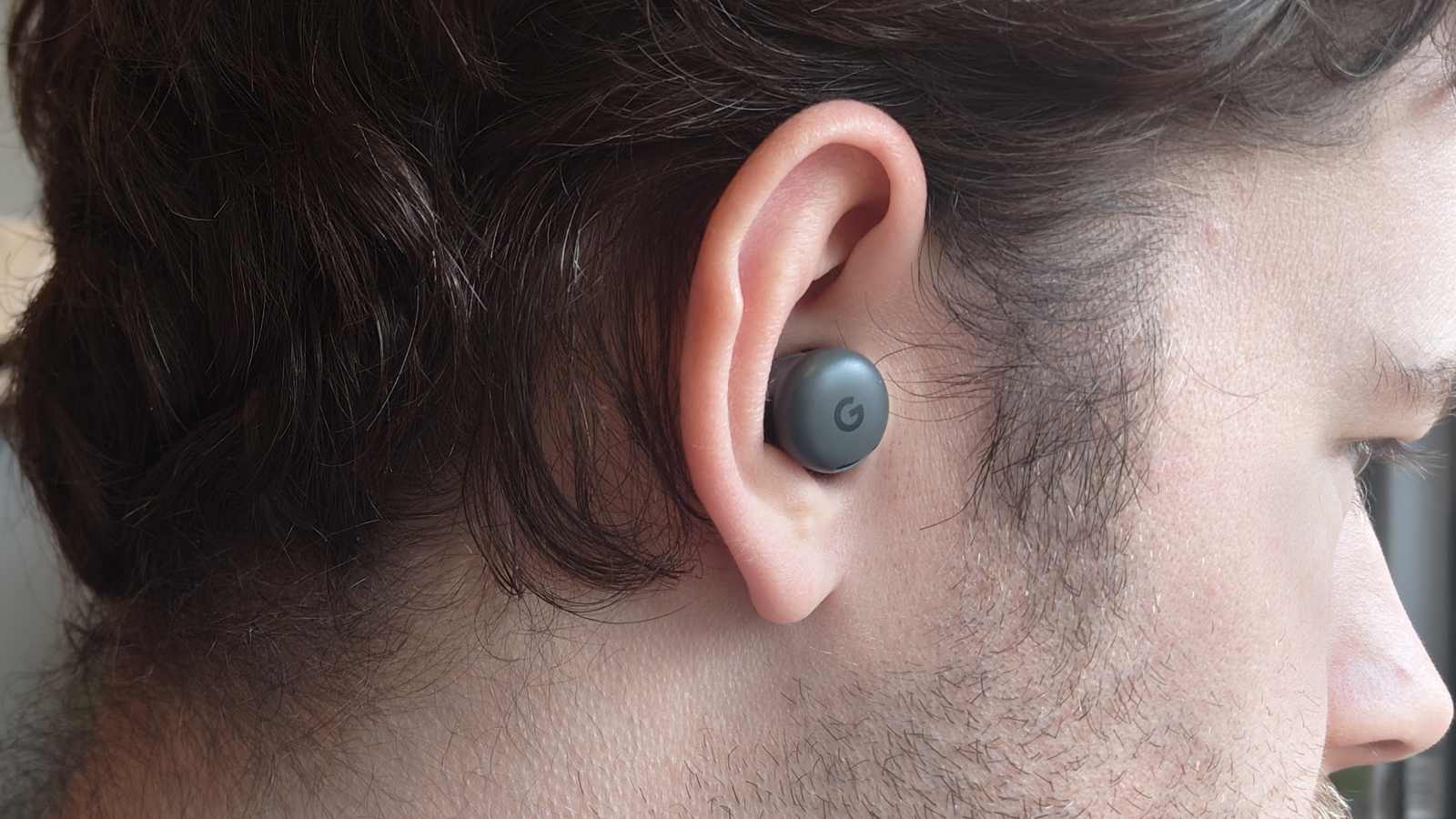 The Google Pixel Buds 2a in a man's ear.