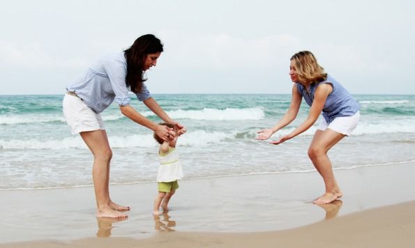 Two moms with their baby on the beach