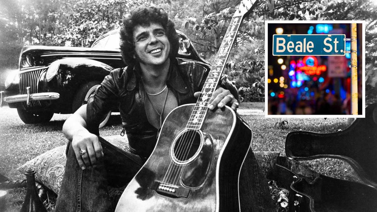 Songwriter and guitarist Bobby Whitlock poses for a portrait in front of an old car next to a bottle of Dom Perignon champagne holding an acoustic guitar in circa 1975