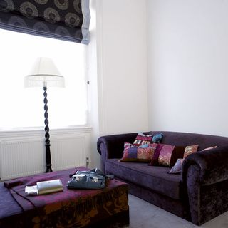 sofa with cushions and white walls with lamp