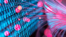 Blue-colored binary code on a computer screen with pink fiber optic cables touching screen. 